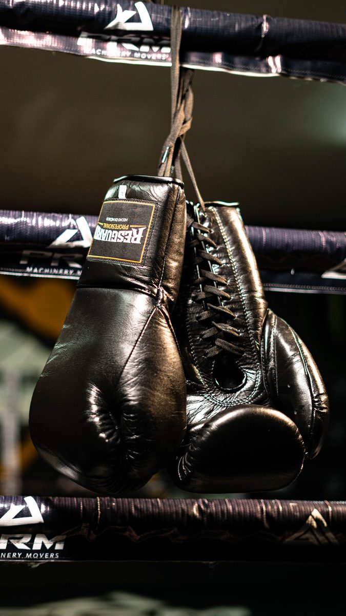 Guantes colgados con luz cálida del gimnasio